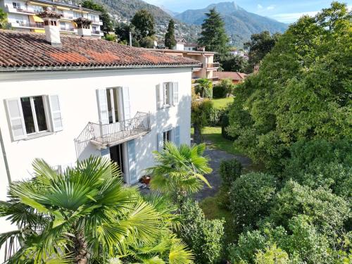 une vue d'une maison blanche avec des arbres dans l'établissement Villa dei Muralti, à Muralto