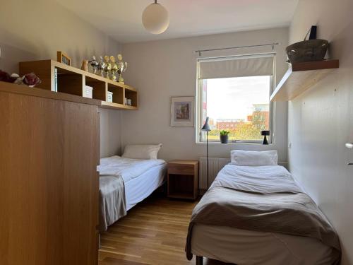 レイキャビクにあるModern 2BR Apartment with Balcony and Stunning Viewsの窓のある小さな部屋にベッドが2つある
