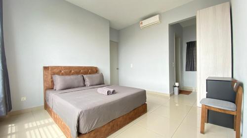ein Schlafzimmer mit einem Bett und einem Stuhl und einem Fernseher in der Unterkunft Greenfield Regency by Antlerzone in Johor Bahru