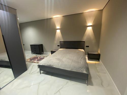 een slaapkamer met een bed en twee lampen aan de muur bij Central Guesthouse in Kapan