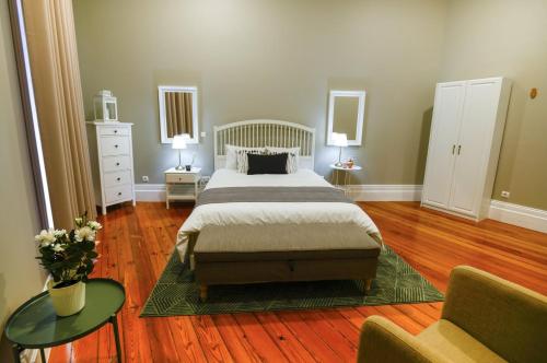 a bedroom with a bed and two tables and two lamps at GuestReady - Casa Conforto & Chiado in Ponta Delgada