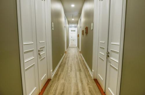 a hallway with white doors and a wooden floor at GuestReady - Casa Conforto & Chiado in Ponta Delgada