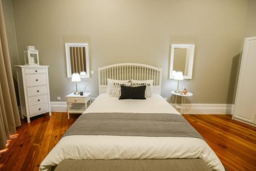a bedroom with a large bed with two tables and two lamps at GuestReady - Casa Conforto & Chiado in Ponta Delgada