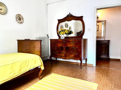 a bedroom with a dresser with a mirror and a bed at A casa della nonna in Imola