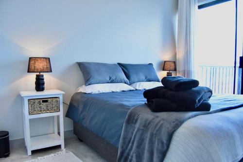 ein Schlafzimmer mit einem Bett und einem Nachttisch mit zwei Lampen in der Unterkunft KB's Beach House in Langstrand