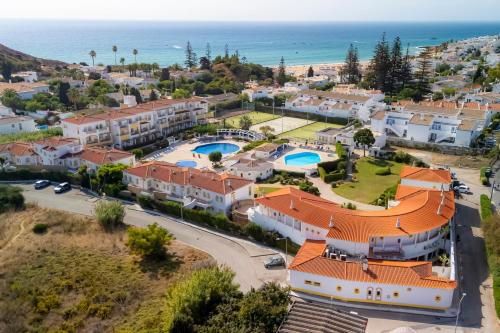 an aerial view of a town with houses and the ocean at Luz Bay Hotel in Luz