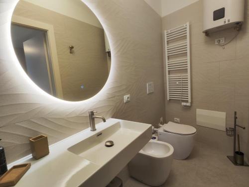 a bathroom with a sink and a toilet and a mirror at Hotel Minerva in Ravenna