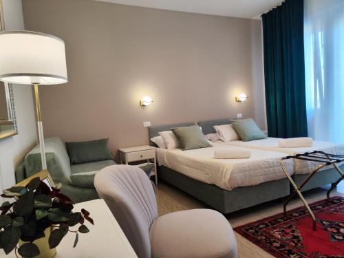 a bedroom with a bed and a living room with a couch at Hotel Minerva in Ravenna
