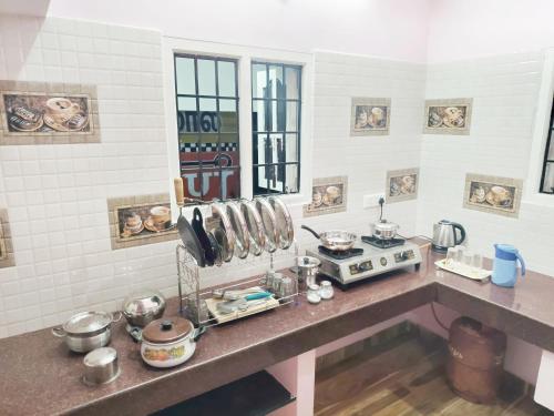 a kitchen with a counter top with pots and pans at Miracle Stay in Madurai
