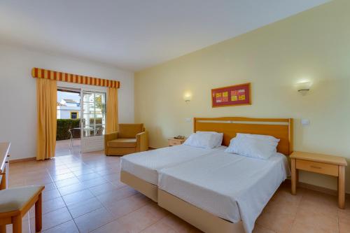 ルースにあるLuz Bay Hotelのベッドと椅子と窓のある寝室