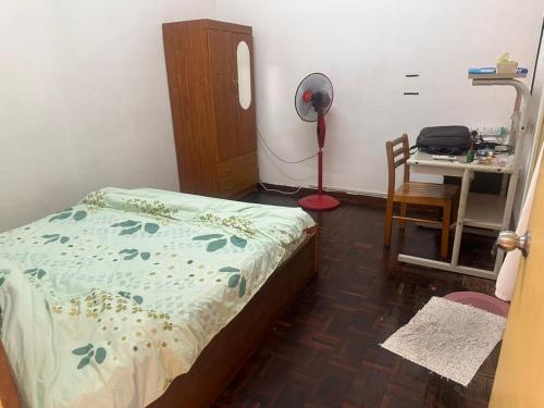 a bedroom with a bed and a desk with a fan at Sweet home Beverly hills in Penampang
