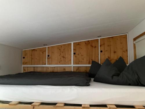 a bedroom with a large bed with wooden cabinets at Tiny House Ruhr im PIER9 Tiny House Hotel in Hamm