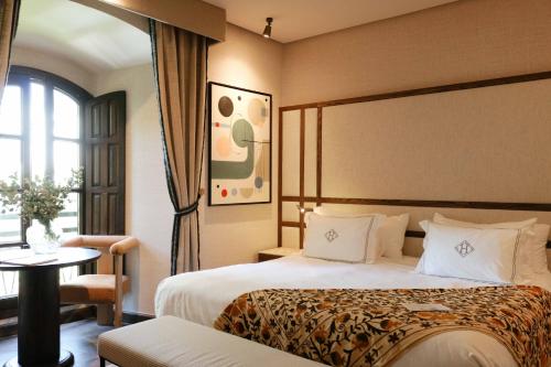 een hotelkamer met twee bedden en een raam bij Hospes Palacio del Bailio, a Member of Design Hotels in Córdoba