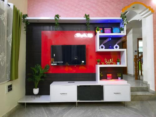 a living room with a flat screen tv on a wall at Flickstays Elara in Bangalore