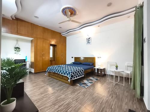 a bedroom with a bed and a table and chairs at Flickstays Elara in Bangalore