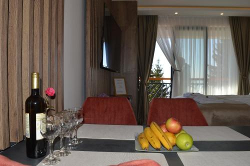 Una mesa con una botella de vino y un plato de fruta. en ViS, en Kopaonik