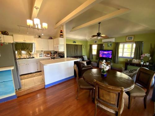 Una cocina y una sala de estar con mesa y sillas. en Eco Friendly Secluded OceanView Pool near Key West, en Cudjoe Key