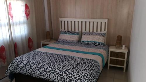 a bedroom with a bed with a white and blue comforter at Christmas Rock, East London in Christmas Vale