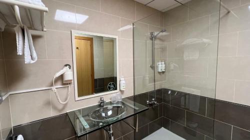 a bathroom with a sink and a shower with a mirror at B&B HOTEL Tarragona Reus in Reus