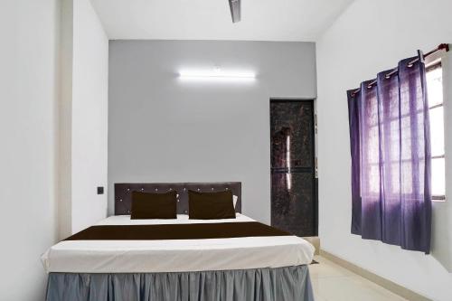 een slaapkamer met een groot bed met paarse gordijnen bij Hotel O Dream Star in Bhilai