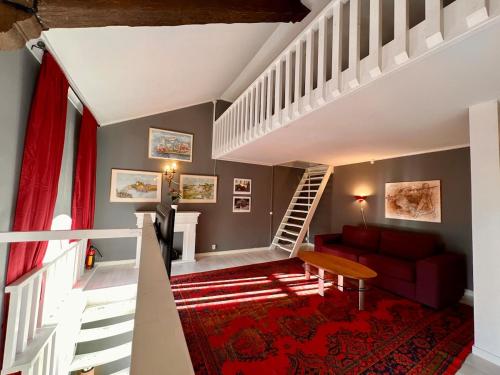a living room with a red couch and a staircase at Centrally-located Unique Private apartment with 3 floors in Smedjebacken