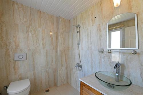 bagno con lavabo in vetro e servizi igienici di Villa Mevsim a Kaş