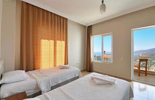 una camera da letto con due letti e una grande finestra di Villa Mevsim a Kaş