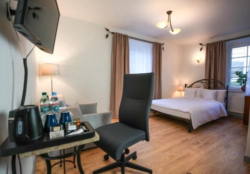 a hotel room with a bed and a desk with a television at Villa Admiral in Gdynia
