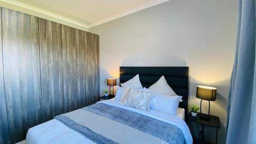 a bedroom with a large bed with white sheets and pillows at Sun-Ash Sea Gardens in Port Shepstone