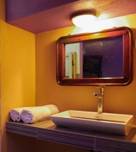 ein Badezimmer mit Waschbecken, Spiegel und Handtüchern in der Unterkunft OYO Hotel Oasis, Monterrey in Monterrey