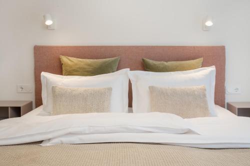 a white bed with four pillows on top of it at Design-Apartment am Chiemsee in Rimsting