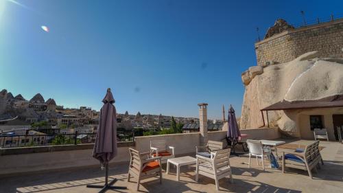a patio with tables and chairs and umbrellas at Grand Elite Cave Suites in Goreme