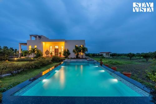 a villa with a swimming pool at night at StayVista at Casa Shwika with Pool and Lawn in Hyderabad