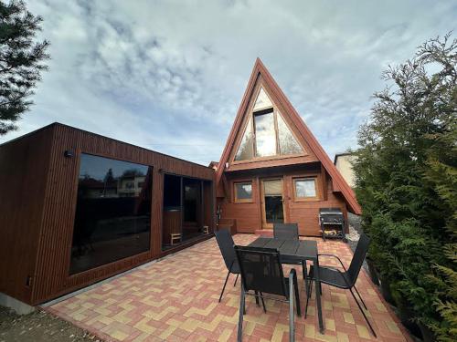 a house with a patio with a table and chairs at Chata Triangel Komjatná in Komjatná