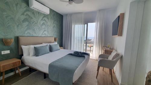 a bedroom with a bed and a chair and a window at Serena del Mar by LIVVO in Playa Blanca