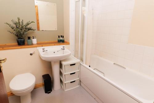 a bathroom with a sink and a toilet and a bath tub at The Sound Rest, Lerwick in Lerwick