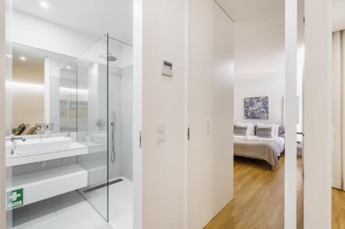 a white bathroom with a sink and a bed at Casa do Alcaide - Minhos Guest in Braga