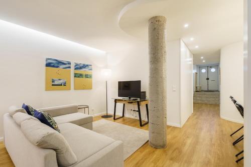 a living room with a couch and a tv at Casa do Alcaide - Minhos Guest in Braga