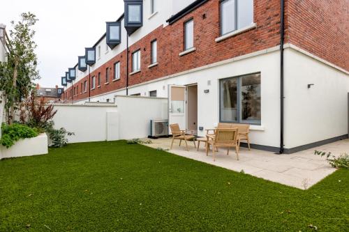 a garden with a lawn in front of a building at New 2-Bed Home with Garden Near Google Dublin HQ & Train Station in Dublin