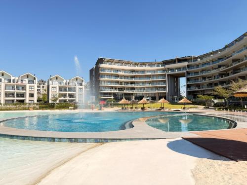 a swimming pool with a fountain in front of a building at Luxury lagoon at Munyaka in Midrand