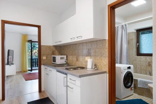 una cocina con gabinetes blancos y una lavadora y secadora en Ferienwohnung Bergblick, en Triberg