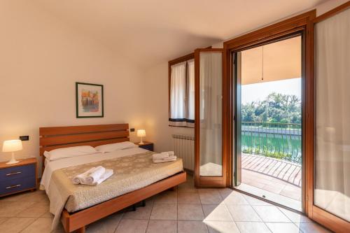 a bedroom with a bed and a large sliding glass door at Bungalow S3 in Isola Albarella