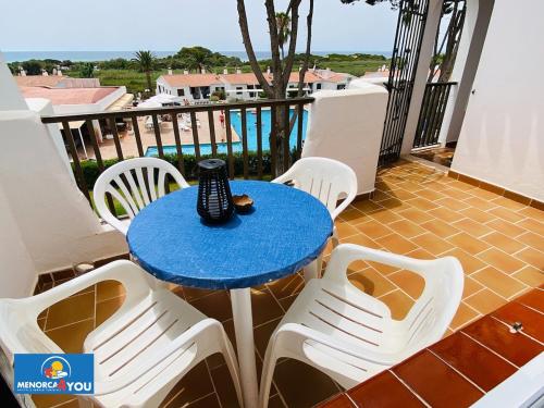 een blauwe tafel en witte stoelen op een balkon bij Appartamento Safir Son Bou con vista mare e piscina in Son Bou
