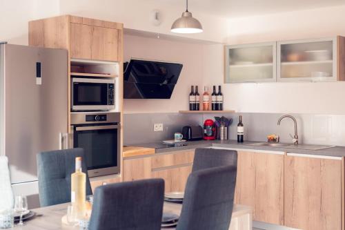 a kitchen with wooden cabinets and a table with chairs at Villa Paulina village heart near the beaches in Portiragnes