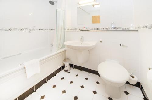 a white bathroom with a toilet and a sink at The Worcester Whitehouse Hotel in Worcester