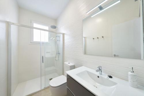 een witte badkamer met een wastafel en een douche bij Eryan II in San José