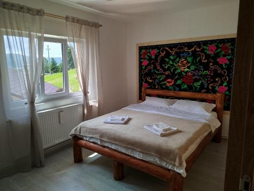 a bedroom with a bed with two towels on it at GreenHeart-Măguri in Măguri-Răcătău