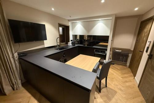una cocina con una gran encimera negra y una mesa en La Forêt 15, en Méribel