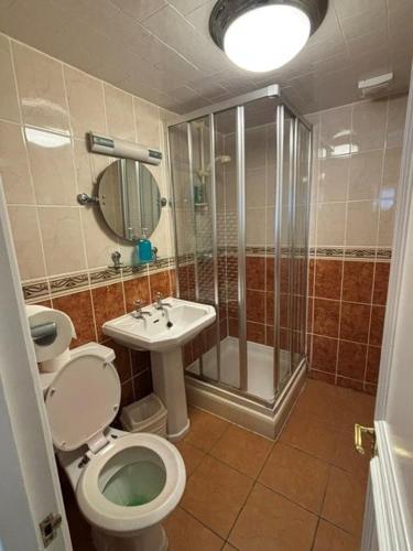 a bathroom with a shower and a toilet and a sink at Hotel de Ville in Ramsgate
