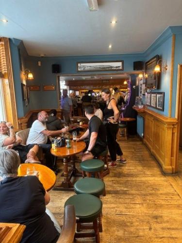 a group of people sitting at tables in a restaurant at Hotel de Ville in Ramsgate